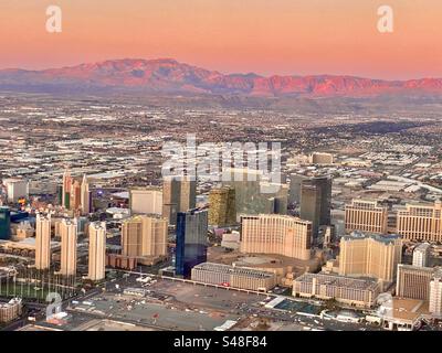 Blick auf Las Vegas bei einem wunderschönen Sonnenaufgang, der den Horizont und die Berge in leuchtenden Rosa- und Orangetönen bedeckt Stockfoto