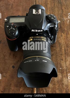 Nahaufnahme einer Nikon D500 DSLR mit einer Nikkor 24 mm 1:1,8 auf einem Holztisch Stockfoto