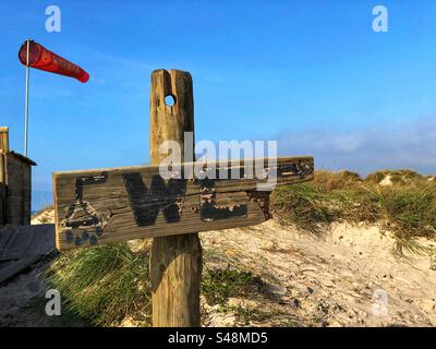 Das WC Holzschild mit der Sanddüne und der Windsocke mit der Aufschrift SUPER BOCK im Hintergrund an einem sonnigen Tag in Esposendo, Portugal, 18. November 2023 Stockfoto