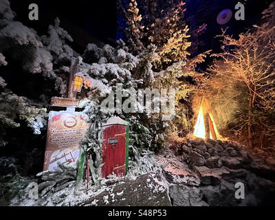 Eine Miniaturtür und ein gefälschtes Feuer in einer Winterszene im Freizeitpark Liseberg in Göteborg, Schweden. Stockfoto