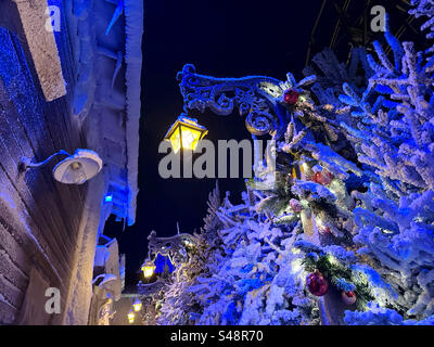 Eine Winterszene mit Straßenlaternen und falschem Schnee im Freizeitpark Liseberg, Göteborg, Schweden. Stockfoto