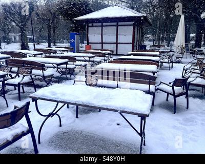 Außerhalb der Saison in einem geschlossenen Café im Jelitkowski Park, Danzig, Polen, Europa, EU, Tische und Stühle im Freien mit Schnee bedeckt Stockfoto