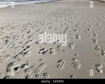 Viele Fußabdrücke und Fußabdrücke im Sand am Atlantic Beach, Florida, USA. Stockfoto