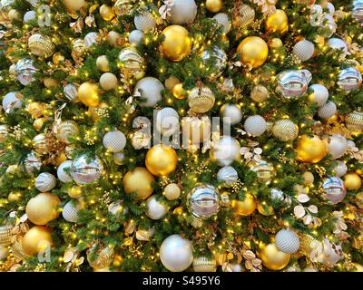 Goldene und silberne Weihnachtsdekorationen auf einem Baum Stockfoto