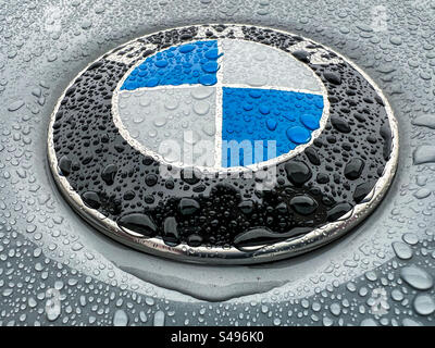 Nahaufnahme eines BMW-Emblems an einem Fahrzeug bei Regen Stockfoto