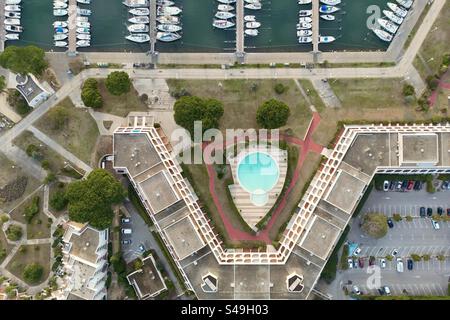 Luftdrohnenaufnahme einer modernen Marina-Residenz und eines Schwimmbades am Meer mit Blick auf den Hafen in Port Camargue, Occitanie, Frankreich. Stockfoto