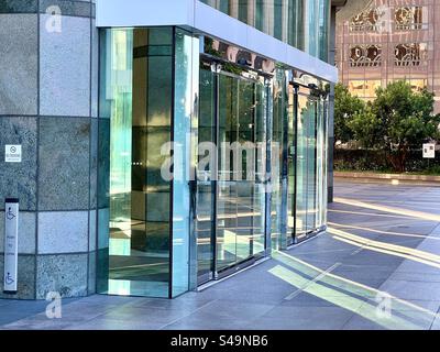 LOS ANGELES, CA, 5. August 2023: Am späten Nachmittag scheint Sonnenlicht durch die getönten Fenster eines Bürogebäudes in Downtown und erzeugt lange grüne Lichtstrahlen auf dem Boden Stockfoto