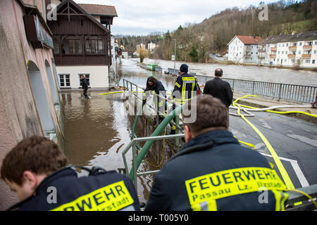 Passau, Deutschland. 16 Mär, 2019. Feuerwehrmänner Pumpe Wasser aus einem Eingang. Die Flut der Ilz hat überflutete Straßen und Grundstücke in Teilen von Passau und hat aufgefüllt Kellern. Quelle: Tobias Köhler/dpa/Alamy leben Nachrichten Stockfoto