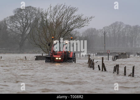 North Yorkshire, UK. 16. März 2019. Landwirt kommend auf der A 684 in der Nähe von Hawes, North Yorkshire überflutet, wie der Fluß Ure die Ufer in der Sintflut, die durch Sturm Hannah. Credit: Wayne HUTCHINSON/Alamy leben Nachrichten Stockfoto