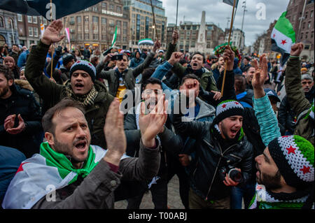 Amsterdam, Nordholland, Niederlande. 16 Mär, 2019. Eine Gruppe von syrischen Männer gesehen, singen Lieder während der Demonstration. Der syrischen Gemeinde in den Niederlanden, der Dam Platz im Zentrum von Amsterdam nahm für Freiheit und Menschenwürde zu verlangen nach 40 Jahren repressive Diktatur. Vor acht Jahren, fing eine Revolution in Syrien. Die Proteste ein Bürgerkrieg, der Millionen Vertriebenen hat, was zu einer der größten humanitären Flüchtlingskrise in der modernen Geschichte. Credit: Ana Fernandez/SOPA Images/ZUMA Draht/Alamy leben Nachrichten Stockfoto