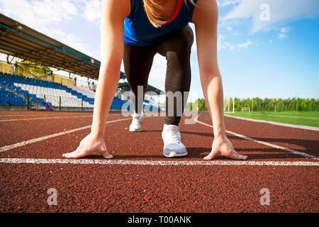 Action Bild einer weiblichen Athleten aus den Startlöchern für einen Sprint laufen auf einer Schiene. Stockfoto