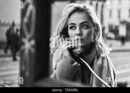 Junge hübsche blonde Frau einen wichtigen Anruf in einem Vintage öffentliche Telefonzelle an einem sonnigen Abend Stockfoto