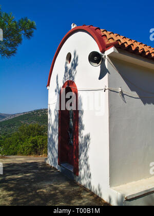 Kleine weiße Kapelle mit lebendigen Farben unter strahlend blauem Himmel. Stockfoto