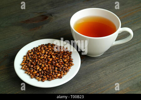 Japanische Mugicha oder Gerste Kaffee mit einem Teller geröstete Gerste auf hölzernen Tisch Stockfoto
