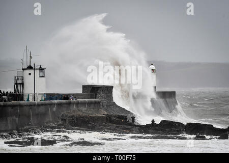 Große Wellen schlagen die Küste als Zuschauer von den Felsen bei Porthcawl, Wales anschauen. Stockfoto