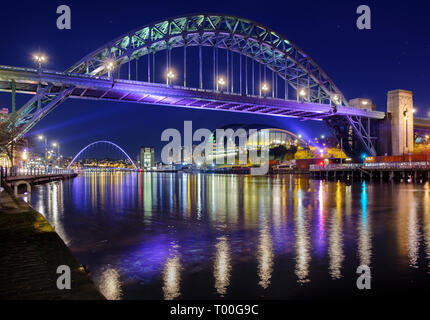 Nach dunklen Fluss Tyne, Brücken zwischen Newcastle Gateshead durch die Tyne Bridge und Millennium Bridge, die Lichter der Stadt in der Nacht überspannt. Stockfoto