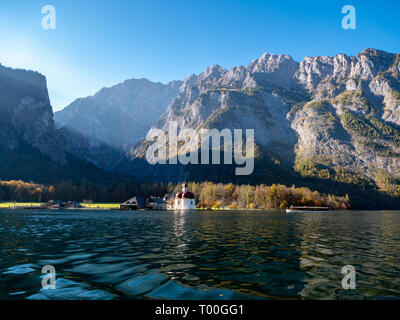 Bild der Königssee mit der Kapelle des Hl. Bartholomäus und ein touristenboot. Im Hintergrund das beleuchtete Gebirgsbildung der Watzmann in bava Stockfoto