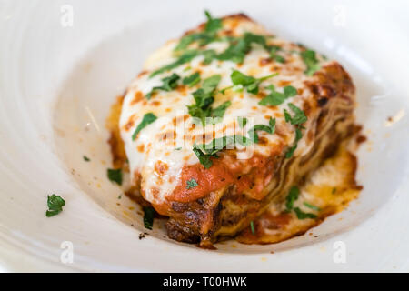 Teil ein leckeres Rindfleisch Lasagne mit Schmelzen Cheddar, Mozzarella und Ricotta Käse, garniert mit Petersilie Stockfoto