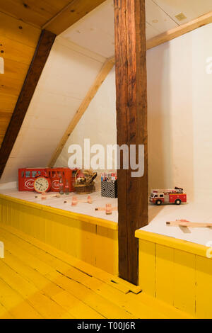 Vintage Spielzeug und leerer Coca-Cola Flaschen auf erhöhten Plattform in Zimmer im Dachgeschoss mit Gelb lackiert pinewood Dielen in alten circa 1760 Home Interior Stockfoto