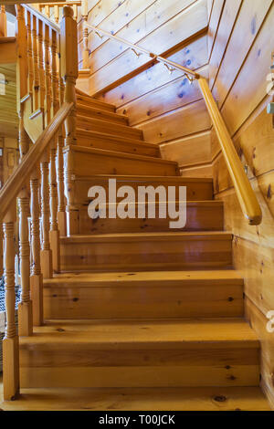 Die Kiefernholztreppe führt vom Wohnzimmer in die obere Etage, in ein Stück östliches weißes Kiefernholz- und Holzhaus. Stockfoto