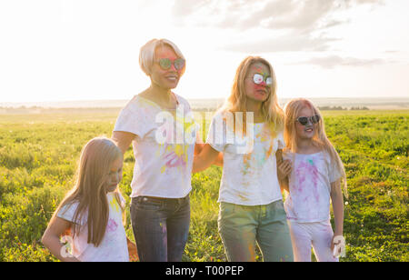 Festival der Holi, Freundschaft, Glück und Urlaub Konzept - Mädchen und Frauen in Gläser umarmen auf dem Festival von Holi. Stockfoto