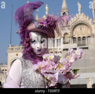 Frau gekleidet in traditionelle Maske und Kostüm für Karneval in Venedig stehen auf dem Piazza San Marco vor Saint Mark's Basilika, Venedig, Venetien, Ital Stockfoto