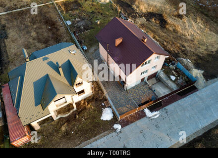 Antenne Blick von oben auf die beiden neuen Wohnhäuser Ferienhäuser mit Schindeldach auf umzäunten großen Yards auf sonnigen Tag. Stockfoto