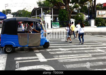ANTIPOLO CITY, Philippinen - 11. MÄRZ 2019: ein Dreirad Treibern können Fußgänger die Straße überqueren, bevor Sie in den Weg. Stockfoto