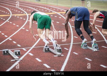 Schülerinnen und Schüler beteiligen sich in einer Schiene und Feld 100 Meter dash Rennen Stockfoto