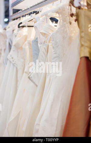 Mit vielen schönen Brautkleider im Showroom stehen. Stockfoto