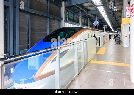 Hokurikui Shinkansen, E7-Serie, bei der Plattform in Kanazawa Station. Ansicht von vorne auf der Suche entlang der Länge des Zuges. Stockfoto