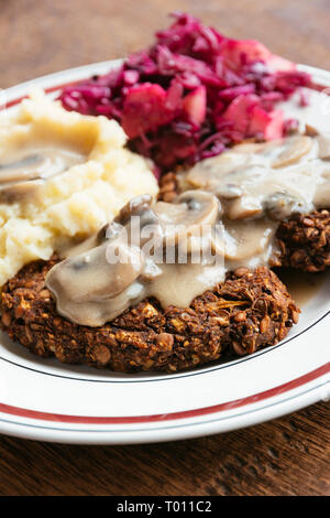 Linsen-Pilz Burger mit Kartoffelpüree und Rotkraut Stockfoto