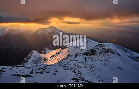 Aufsteigend Ciemniak Berg bei einem Sonnenuntergang kommt durch stürmische Wolken. Stockfoto