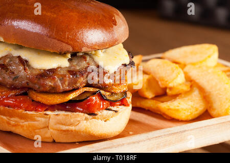 Hamburger Rindfleisch, Gemüse, Käse, Brot, Kartoffeln Pommes frites Sauce fast food hölzernen Tisch servieren Mahlzeit schnell Öl Küche moderne Papierkorb trashfood Stockfoto