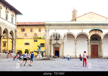 Jungs im Teenageralter kick ein socerball rund um die Piazza della Santissima Annunziata in Florenz, in der Region Toskana, Italien. Stockfoto