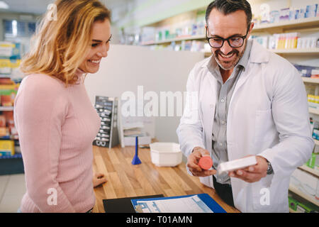 Apotheker angezeigt und Beratung Medizin für weibliche Kunden in der Apotheke. Apotheker, medizinische Droge zu weiblichen Käufer in der Medizin. Stockfoto