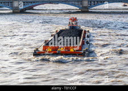 Thames barge wird durch einen Fluss tug geschoben. Lose Ware auf dem Fluss auch heute noch den Bedarf für den Straßenverkehr und nach unten verschoben. Stockfoto