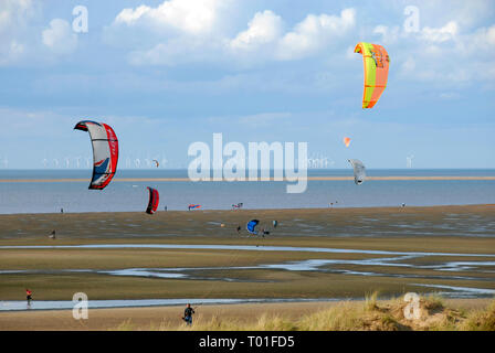 Drachen fliegen am Strand, Hunstanton, Norfolk, England, mit Windparks in der Ferne Stockfoto