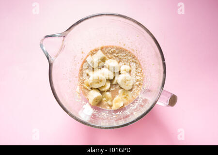 Visual Guide aus ein Foto zeigt die verschiedenen Schritt eine Banane Brot vorzubereiten, Hinzufügen reife Bananen zu der Mischung in eine Schüssel geben, Ansicht von oben Ove Stockfoto