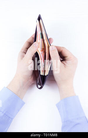 Den Beutel mit dem Geld in der Hand auf einem weißen Hintergrund Stockfoto