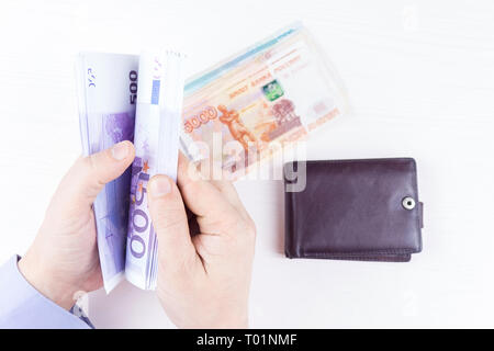 Den Beutel mit dem Geld in der Hand auf einem weißen Hintergrund Stockfoto