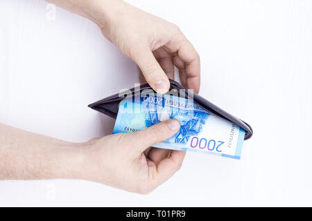 Den Beutel mit dem Geld in der Hand auf einem weißen Hintergrund Stockfoto