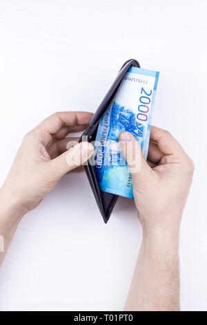 Den Beutel mit dem Geld in der Hand auf einem weißen Hintergrund Stockfoto