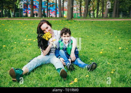 Cute fröhliches Kind mit Mutter spielen draußen im Park. Morthers Tag Stockfoto