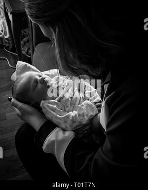 Friedliche Bild der Mutter holding newborn baby am ersten Tag aus dem Krankenhaus nach Hause. Exzellent für Muttertag, Pro Life/pro Wahl Artikel Stockfoto