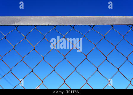 Drahtgitter chain-link Fence mit blauem Himmel Hintergrund und Copyspace Bereich für sicherheitsgrenze auf Basis Ideen und Themen Stockfoto