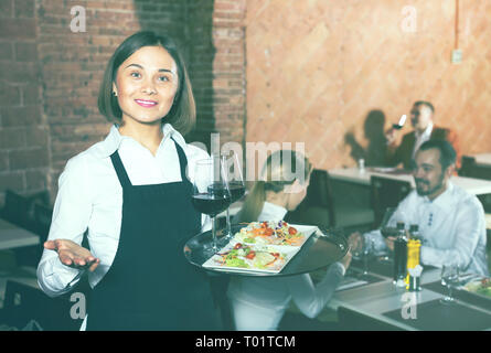 Lächelnd weibliche Kellner die Gäste zu Land Restaurant Stockfoto