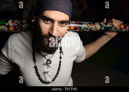 Dunkel, Nahaufnahme, Porträt eines Mannes mit Piercings und bandana. Stockfoto