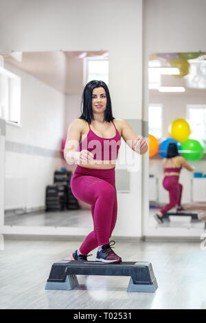 Sportliche Mädchen Züge auf Stepper in der Turnhalle. Das Konzept der Sport, eine gesunde Lebensweise, Gewicht zu verlieren. Stockfoto