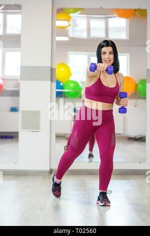 Nach sportlich Frau Übungen mit Hanteln. Das Konzept der Sport, eine gesunde Lebensweise, Gewicht zu verlieren. Stockfoto